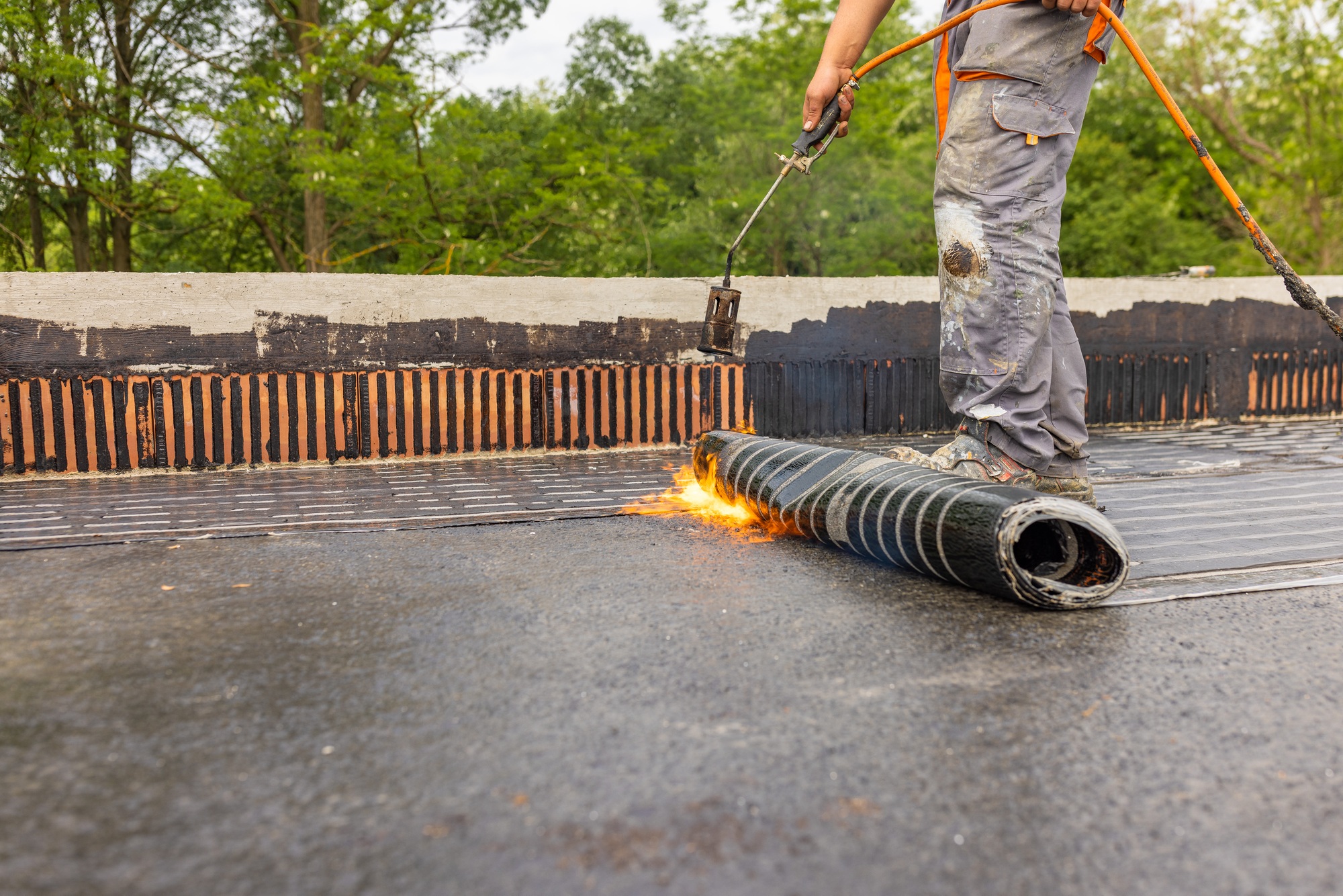 Bituminous membrane waterproofing system details and installation on flat rooftop.